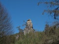 Sandstone rock pillar in spring landscape r Lusatian Mountains with fresh deciduous and spruce tree forest. Blue sky