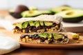 sandwich with avocado slices, black beans, and corn