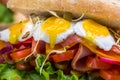 A sandwich with bacon, cheese and fried quail eggs. A sandwich with fresh vegetables and herbs on a wooden background. Royalty Free Stock Photo