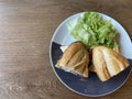 Sandwich baguette bacon and fried egg with salad on black white plate on wooden table Royalty Free Stock Photo