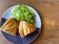 Sandwich baguette bacon and fried egg with salad on black white plate on wooden table Royalty Free Stock Photo