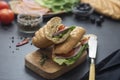 Sandwich with baguette bread, ham, lettuce, tomatoe over dark background. Breakfast or fast food Royalty Free Stock Photo