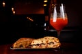 Sandwich in a bar on a wooden table. A tulip glass of beer on the background. Royalty Free Stock Photo