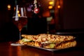 Sandwich in a bar on a wooden table. A tulip glass of beer on the background. Royalty Free Stock Photo