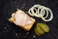 Sandwich with becon, onions and pickled cucumber