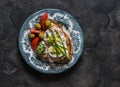 Sandwich with boiled egg, ham, asparagus and tomatoes, olives in a plate on a dark background, top view Royalty Free Stock Photo