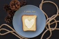 sandwich for breakfast in form of heart with cheese on a blue plate and black background with cones inscription I love Royalty Free Stock Photo