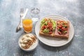 Sandwich breakfast has ham cheese and tomato cucumber and yoghurt on blue wood table