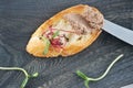 Sandwich of burnt toast with pate and herbs on a dark wooden Boa