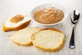 Sandwich with caviar, bread, bowl with salted pollock caviar, spoon on table