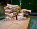 Sandwich with cheese and ham on cutting board in the blurred kitchen background. Close up Royalty Free Stock Photo