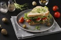 Sandwich with chicken, cherry tomatoes, quail eggs and microgreens against a dark background Royalty Free Stock Photo