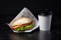 Sandwich and coffee on the black background. Fastfood. Burgeer.