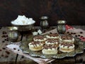 Sandwich cookies with cream decorated with chocolate on a metal platter and sprinkle with coffee beans around. Royalty Free Stock Photo