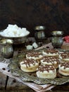 Sandwich cookies with cream decorated with chocolate on a metal platter and sprinkle with coffee beans around. Royalty Free Stock Photo