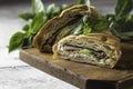 Sandwich croissant with cucumber, avocado, tomato, spinach, beef pastrami, sauce on wooden board. Royalty Free Stock Photo