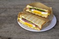 Sandwich cut in half. Two pieces of sandwich with ham, egg, lettuce, tomatoes and sauce in a white plate on old wood table. Top Royalty Free Stock Photo