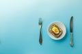 Sandwich with egg and avocado on a white plate on a blue background, top view Royalty Free Stock Photo