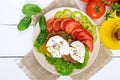 Sandwich with egg poached, lettuce, black bread with seeds, tomatoes, sweet pepper on a plate Royalty Free Stock Photo