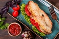 Sandwich with fillet grilled chicken, lettuce, tomatoes, cheese and traditional bread loaf out of the oven on dark background. Royalty Free Stock Photo