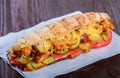 Sandwich from fresh pita bread with fillet grilled chicken, lettuce, slices of fresh tomatoes, pickles and cheese Royalty Free Stock Photo