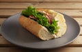 Sandwich with fresh vegetables on a ceramic gray plate. Wooden brown background. Vegetarian sandwich. Close-up Royalty Free Stock Photo