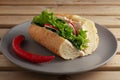 Sandwich with fresh vegetables on a ceramic gray plate. Wooden brown background. Vegetarian sandwich. Close-up Royalty Free Stock Photo