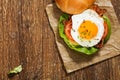 Sandwich with a fried egg, bacon, cheese and vegetables Royalty Free Stock Photo