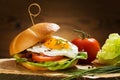 Sandwich with a fried egg, bacon, cheese and vegetables Royalty Free Stock Photo