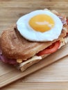 Sandwich with a fried egg, bacon, cheese and vegetables Royalty Free Stock Photo