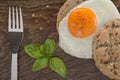 Sandwich with a fried egg on a wooden table.