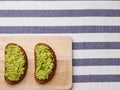 Sandwich with guacamole on light textile background top view. sandwiches on wooden board