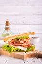 Sandwich with ham, cheese and onion on a wooden board on the table vertical view Royalty Free Stock Photo