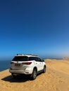 White off-road SUV car at Sandwich Harbour in Namibia at coast of Atlantic Ocean Royalty Free Stock Photo