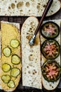 Sandwich making baguette halves spread with mustard and pickles