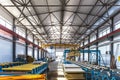 Sandwich manufactory panel production line. Equipment machine tools and roller conveyor in large hangar or workshop