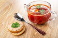 Sandwich with meat pate, bread, spoon, transparent bowl with borscht on wooden table