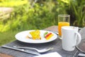 Sandwich with open poached egg and pepper on a plate and coffee with juice on the table