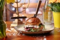 Sandwich with pastrami, vegetables, mimolette cheese, with a sweet roll, on a plate, on a wooden table, side view. Royalty Free Stock Photo