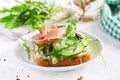 Sandwich with prosciutto, cucumber, black olives, arugula and feta cheese