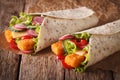 Sandwich roll with fishfingers, cheese and vegetables close-up. Royalty Free Stock Photo