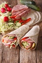 Sandwich roll stuffed with ham, cheese, vegetables close-up. Vertical Royalty Free Stock Photo