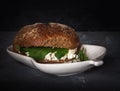 Sandwich of rye bread, curd cheese and arugula salad.