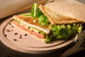 Sandwich with rye brown bread, frash satad and red fish on wooden board Royalty Free Stock Photo