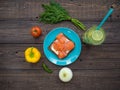 Sandwich with salmon, black bread on a plate, vegetables and a glass of lemonade