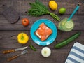 Sandwich with salmon, black bread on a plate, vegetables and a glass of lemonade