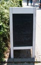 Sandwich sign blackboard with white wooden frame. Blackboard shows shadows of erased white chalk