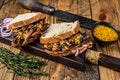 Sandwich with slow smoked pulled pork meat on white bread. wooden background. Top view
