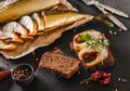 Sandwich with smoked mackerel fish with spices on dark stone background. Smoked fish, mediterranean food, herring fish, seafood,