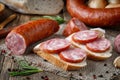 Sandwich with smoked sausage. Dry-cured sausage, bread and spices Royalty Free Stock Photo